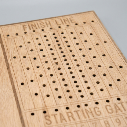 Horse race board game - close-up of laser-engraved finish line scoring track and peg holes, studio macro shot